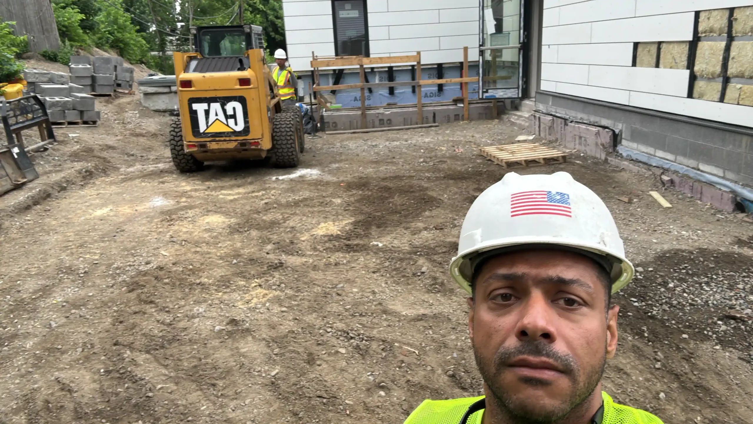 Construction site with landscaping equipment and masonry work